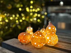 some orange lights sitting on top of a wooden table next to a christmas tree in the background