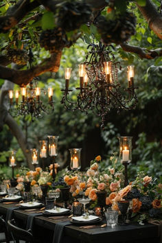 an outdoor dinner table with candles and flowers