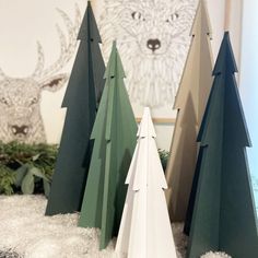 three paper trees sitting on top of snow covered ground