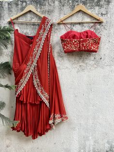 Rust Red georgette pre-stitched ruffle saree with hand embroidered pallu ans scallop detailing paired with zari worl bustier Designer Red Pre-draped Saree With Ruffles, Traditional Draped Sets With Ruffles, Festive Red Sharara With Ruffles, Festive Draped Ruffle Sets, Red Draped Georgette Choli, Bollywood Style Red Ruffled Sharara, Red Embellished Georgette Pre-draped Saree, Red Embellished Pre-draped Georgette Saree, Festive Red Lehenga With Ruffles