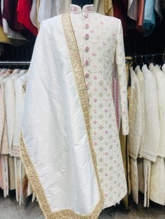 Item Contains :  Sherwani  Kurta  Pyjama and  Shoes Colours :  Greenish Ivory  Fabrics :  Pure silk premium fabric  Embroidery :  All over work over the sherwani is a mix of hand work zardosi and thread work which comprises of beads squares in the centre a flowers is highlighted with magenta and peach resham thread and round shaped beads and sequences and it's has all over cotton thread work too on back  Style and Design :  Sherwani has mandarin collar and long sleeves with a full button placket Bollywood Art Silk Sherwani With Chikankari Embroidery, Naqshi Embroidered Straight Kurta Sherwani For Reception, Naqshi Embroidered Straight Sherwani For Reception, Naqshi Embroidered Sherwani For Reception, Off White Naqshi Traditional Wear For Festive Occasions, Traditional Bandhgala With Chikankari Embroidery In Art Silk, Art Silk Sherwani With Chikankari Embroidery, Straight Kurta, Off White Kurta With Dupatta In Traditional Drape, Art Silk Sherwani With Chikankari Embroidery