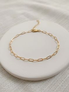 "Please review the sizing guide below for the perfect fit! A simple paperclip chain bracelet is a staple piece for your wardrobe! This is a shiny and versatile bracelet that looks beautiful everyday, or stacked with other gold bracelets for a more bold look! Made with chain sourced in the USA and hand cut to order 💛 * 2.8x6mm 14K Gold Filled or 925 Sterling Silver chain * Dainty 14K Gold Filled or 925 Sterling Silver clasp * 14/20 gf stamp for authenticity * Choose your length (each bracelet co Delicate Everyday Paperclip Bracelet, Minimalist 14k Gold Filled Paperclip Bracelet, Minimalist Gold Paperclip Bracelet, Minimalist Paperclip Chain Bracelet, Minimalist Adjustable Paperclip Bracelets, Adjustable Minimalist Paperclip Bracelet, Dainty Paperclip Chain Bracelet With Delicate Chain, Dainty Adjustable Paperclip Link Bracelet, Dainty Adjustable Paperclip Chain Link Bracelet