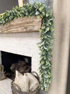 a fireplace decorated with greenery next to a basket