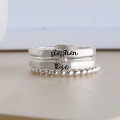 Mother's Day Gift | Personalized stackable ring set, engraved with a name, date, or special word.  Metal: 14k gold filled, 14k rose gold filled, or .999 fine silver Dimensions: name rings are 2mm tall on average, but our rings are handmade so variations will occur. Birthstone is 2mm on a 1mm band and beaded ring is 2mm. Font: lowercase typewriter or lowercase cursive If you leave one name, we will put a heart on the second ring unless you request that it remains blanks. If you have 3 or 4 names, Customizable Adjustable Sterling Silver Engraved Ring, Adjustable Customizable Engraved Sterling Silver Ring, Minimalist Hand Stamped Stackable Wedding Rings, Minimalist Hand Stamped Stackable Rings For Wedding, Personalized Sterling Silver Stackable Rings For Anniversary, Personalized Silver Engraved Ring For Mother's Day, Adjustable Stackable Engraved Ring For Anniversary, Engraved Sterling Silver Birthstone Ring Gift, Gift Sterling Silver Stackable Engraved Ring