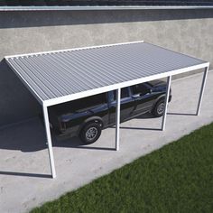 a truck parked under a metal carport on the side of a building next to a grass field