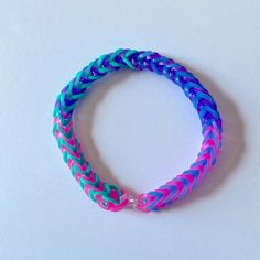 a blue and pink braided bracelet on a white surface