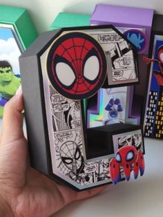 someone is holding up an origami letter with spider - man pictures on it