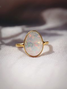 This bold gold statement ring features organic shaped Fire Opal that shines from within. This gorgeous gold ring is sure to become an everyday staple. Wear it solo or stack it with our other favorite rings.✦ DETAILS ✦✧ Name: Hinuhinu (HEE noo HEE noo) - bright, glittering, splendid.✧ Available in whole sizes 5-9. ✧ Synthetic Fire Opal Stone.✧ 18kt Gold Vermeil.✧ All Ke Aloha Jewelry pieces come packaged thoughtfully, beautifully, and ready for gift giving. Modern Opal Ring, Opal Rock, Opal Statement Ring, Gold Moonstone Ring, Rings Sets, Rock Rings, Opal Band, Opal Wedding Rings, Fire Opal Ring