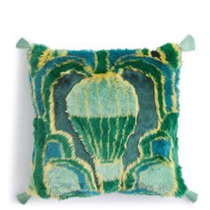 a green and yellow pillow with tassels on it