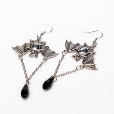 Unleash your inner darkness with these captivating Bat Earrings. Crafted from durable zinc alloy with a striking black finish, each earring measures 1.5 by 1 inch, featuring an elegant 1-inch chain adorned with a black diamond-shaped accent. Perfect for adding a touch of gothic charm to any outfit, these earrings are a must-have for your collection. Inner Darkness, Alternative Earrings, Alchemy Gothic, Dark Elegance, Bat Earrings, Earring Collection, Elevate Your Look, Diamond Shaped, Earrings Collection