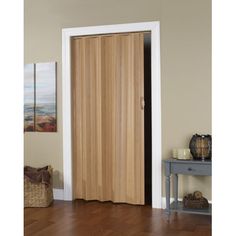 a wooden door in the corner of a room with hardwood flooring and white trim