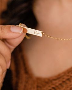 "The daintiness of our personalized name necklace adds the perfect touch to any outfit! The simplicity of this custom necklace allows you to mix and match with a variety of styles to create an elegant look. Beautifully engraved, this customized piece makes the perfect gift for Valentine's Day, Mother's Day, Christmas and all special occasions and milestones!  Material: 14k gold filled, anti-tarnish material (will not turn blue or green and will not stain skin) Bar Size: 1.25\" W x 0.25\" H Chain Initial Birthstone Necklace, Skin Bar, Mother Necklace Personalized, Custom Bar Necklace, Engraved Bar Necklace, Gift For Valentine, Turn Blue, Bar Necklace Personalized, Silver Bar Necklace