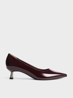 Maroon is a refreshing alternative to black, offering equal elegance and versatility. These pointed-toe pumps are sleek and sophisticated, with a glossy patent finish that adds a touch of understated shine. Set on dainty kitten heels, they provide a comfortable amount of lift. Pair them with anything from pantsuits to pencil skirts for office days. Effortlessly transitioning from day to night, these pumps let you play as hard as you work in style. Kitten Heel Pumps, Pencil Skirts, Charles Keith, Pointed Toe Heels, Pointed Toe Shoes, Flat Boots, Kitten Heels, Shop Now, Pencil