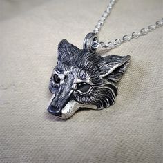 This piece will be handmade for you in the United Kingdom. Please allow me up to 28 days to finish making it. This Silver Wolf has been hand made in the United Kingdom. Grey wolves (Canis lupus), are found in various guises throughout remote areas of the Northern Hemisphere. They have been an essential element in the folk law and literature of almost all cultures and ages.She-wolves are the epitome of maternal protection and feminine strength, they were particularly prevalent in Roman legend and also the title given to England’s war-like medieval queens. The sterling silver wolf measures around 2.5cm (which is close to an inch). It has eyes made from natural, cabochon cut, 4mm grey moonstone gemstones. The silver wolf has been hung from an elegant, yet sturdy 20 inch long solid silver chai Sterling Silver Wolf Design Jewelry, Silver Wolf Pendant Necklace, Silver Wolf Design Pendant Necklace, Silver Wolf Design Round Pendant Necklace, Silver Necklace With Wolf Design Round Pendant, Silver Round Pendant Necklace With Wolf Design, Moonstone Eyes, Grey Wolves, Feminine Strength