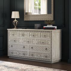 a white dresser sitting in front of a mirror