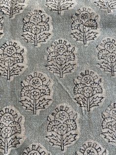 an upholstered fabric with trees and leaves on the side, in grey tones