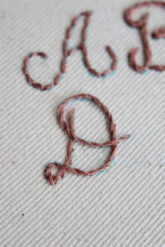 the word yarn is written in brown and blue ink on a white surface with red thread