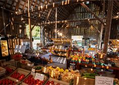 an open market with lots of fruits and veggies in baskets on the tables