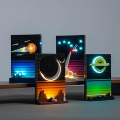 three different colored lights on top of each other in front of a wooden table with a white wall behind them