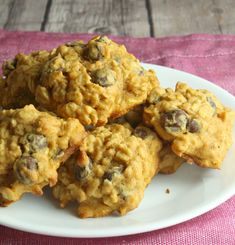 a white plate topped with oatmeal cookies on top of a pink table cloth