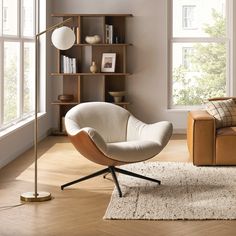 a living room with a chair, couch and bookshelf on the wall next to a window