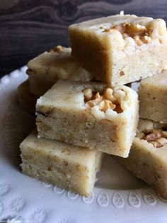 several pieces of cake sitting on top of a white plate with nuts in the middle