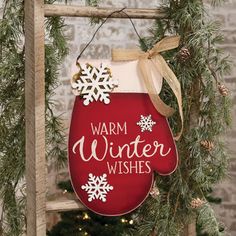 a red christmas ornament hanging from a ladder with snowflakes on it