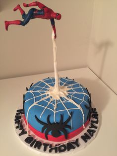 a spiderman birthday cake with sprinkles and icing on the top