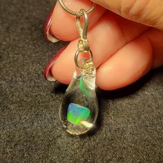 "My friend Marcy named this style of pendants. She said they look like Mermaid's tears. These teardrop dangle pendant is made by melting borosilicate glass tubing (pyrex) and blowing a bubble at the end of the tube in the flame. The Gilson opal is then placed in the tube and is slowly melted so that the Gilson opal can be completely encased by the borosilicate glass and shaped into a teardrop. These opals flash a blue and green color within the glass. I only use first quality borosilicate glass Mermaid Tears, Dangle Necklace, Dangle Necklaces, Necklace Design, Jacksonville Fl, Opal Pendants, Pyrex, Hand Blown Glass, Necklace Designs