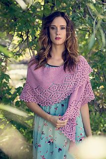 a woman standing in front of trees wearing a purple shawl with flowers on it