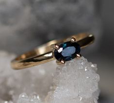 a gold ring with a blue stone on top of some ice crystals in the snow