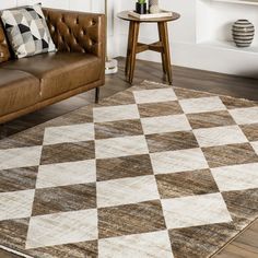 a brown leather couch sitting on top of a checkered rug in a living room