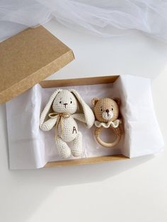 two crocheted stuffed animals in a wooden box on top of a white table