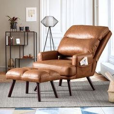 a brown leather recliner chair and ottoman in a living room with a rug on the floor