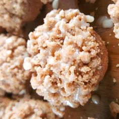 a close up view of some food on a wooden table with white frosting and sprinkles