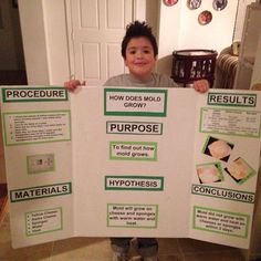 a young boy holding up a poster with instructions on how to grow and use it