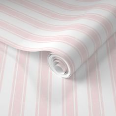 a pink and white striped wallpaper with a rolled up roll on the floor next to it