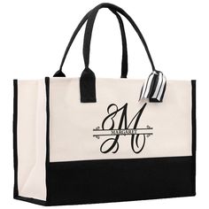 a black and white tote bag with the monogrammed m on it's side