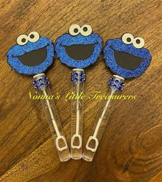 three sesame street cookie cutters with blue glitter on them