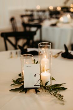 A romantic grouping of hurricane candles on top of  sprigs of greenery is a perfect touch to this elegant and modern wedding reception.

- Olivia Doerfler Photography Modern Simple Wedding Centerpieces, Minimal Candle Wedding Decor, Very Simple Wedding Centerpieces, Modern Nature Wedding, 3 Candle Centerpiece, Simple Greenery Wedding Decor, Wedding Table Decorations Simple Elegant, Simple Wedding Table Decor Candles, Candle Center Piece For Wedding Tables