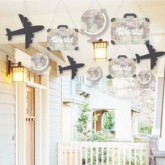 a porch decorated with air planes and hanging from it's ceiling, in front of a white house