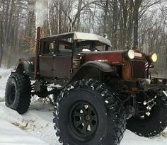 an old truck is parked in the snow