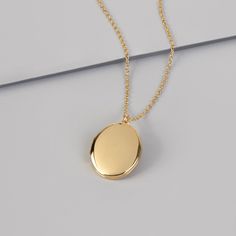 Dainty 14k Gold Locket Necklace, Gold Locket Necklace With Delicate Chain And Round Pendant, Gold Locket Necklace With Delicate Round Pendant, Gold Locket Necklace With Oval Pendant, Dainty Gold Oval Pendant Locket Necklace, Minimalist Gold Jewelry For Keepsake, Minimalist Gold Jewelry As Keepsake, Everyday Yellow Gold Engraved Locket Necklace, Gold Minimalist Necklace For Keepsake