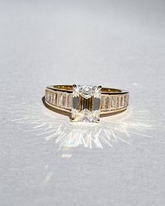 a diamond ring sitting on top of a white surface with the light shining through it