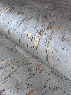 a close up view of the surface of a grey fabric with brown spots on it