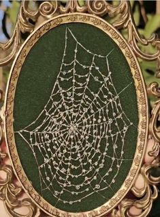 a golden frame with a spider web on it