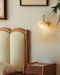 a bed with a wooden headboard and two framed pictures on the wall