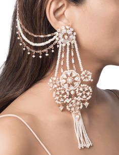 The heritage sahara earrings are handcrafted in base metal with 22 kt gold plating and feature an ornate arrangement of Swarovski cubic zirconia crystals and tiny luminous pearls. Pearl tassels and a layered sahara that hooks onto your hair add a unique and elegant element to the piece. • Plating: 22kt Rose Gold • Stones: Cubic Zirconia • Material: Base Metal Unique Indian Jewellery, Unique Jewellery Designs, Sahara Earrings Hairstyle, Fancy Earrings Fashion, Sahara Earrings, Pearl Tassels, Unique Wedding Jewelry, Unique Bridal Jewelry, Indian Jewelry Earrings