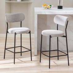 Elevate your kitchen or bar area with this modern 2-piece counter stool set. Crafted with a sleek, powder-coated iron frame in a black hue, they're paired with a comfy, upholstered seat in a polyester blend. The low back design adds a contemporary touch, while the built-in footrest ensures a cozy spot to perch. Plus, the plastic glides protect your floors from scratches. Whether you're enjoying breakfast or cocktails, these stools are ready to impress. Just remember to keep them looking fresh by Padded Bar Stools, Fabric Bar Stool, Counter Seating, Cozy Spot, Counter Height Bar Stools, Bar Area, Boucle Fabric, Modern Bar Stools, Kitchen Bar Stools