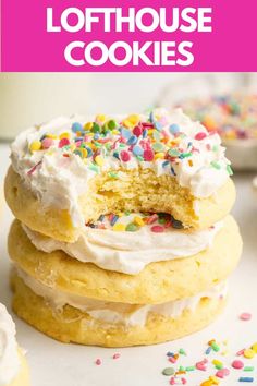 a stack of cookies with white frosting and sprinkles